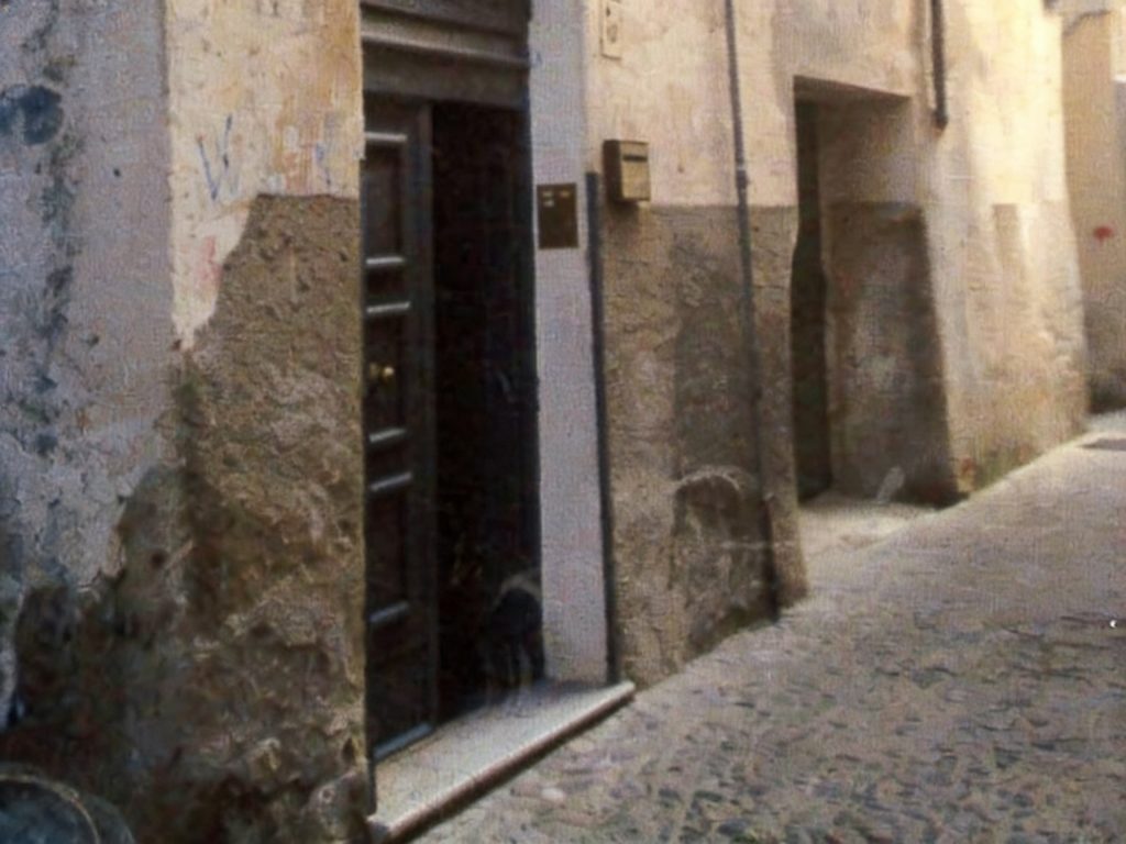 Vicolo buio e trascurato con muri scrostati, macchie di muffa e graffiti, indicando scarsa pulizia e un aspetto deteriorato prima dell'intervento di home staging.