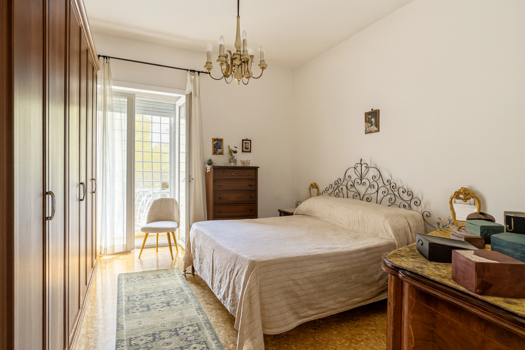 Camera da letto originale disordinata e piena di oggetti prima dell'intervento di svuotamento.