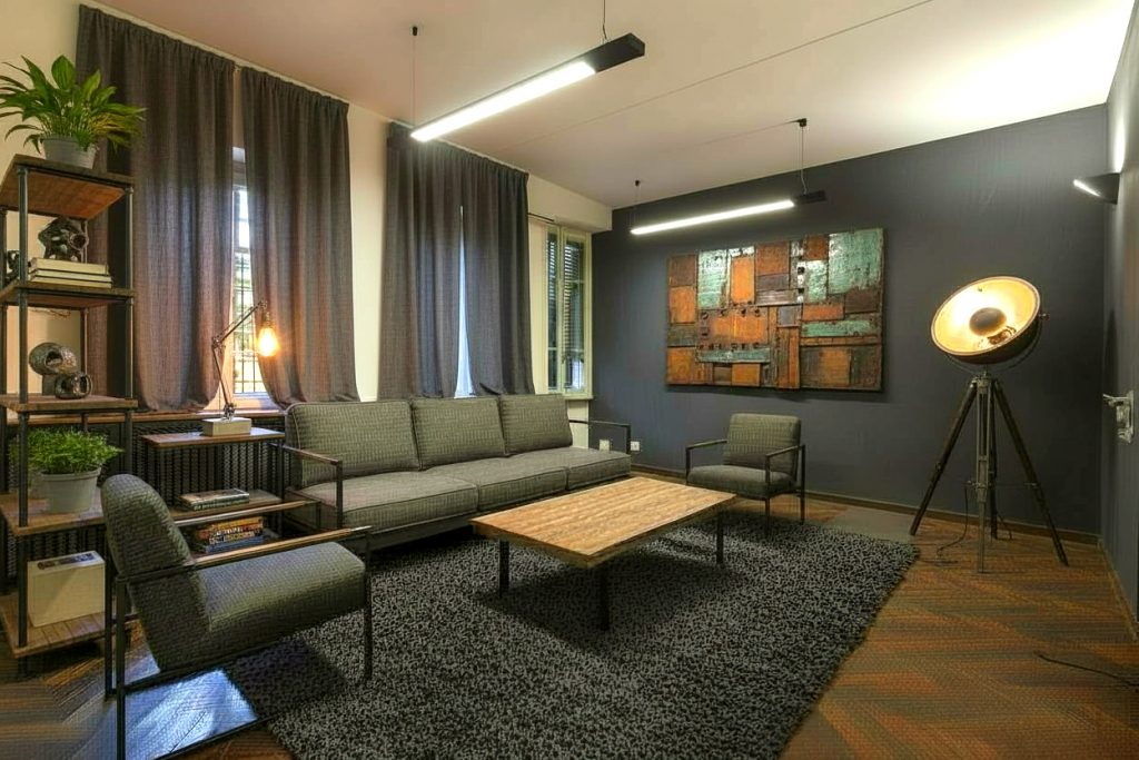 living industrial chic con divano in pelle, parete in mattoni e illuminazione moderna